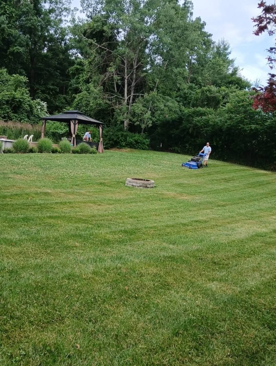Mowing a big backyard with a gazebo and fire pit