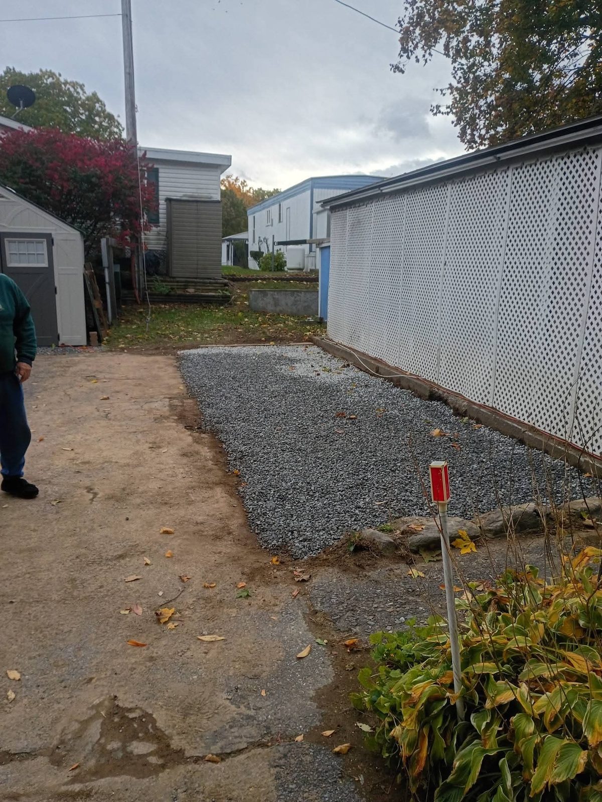 Finished gravel path along a white lattice fence