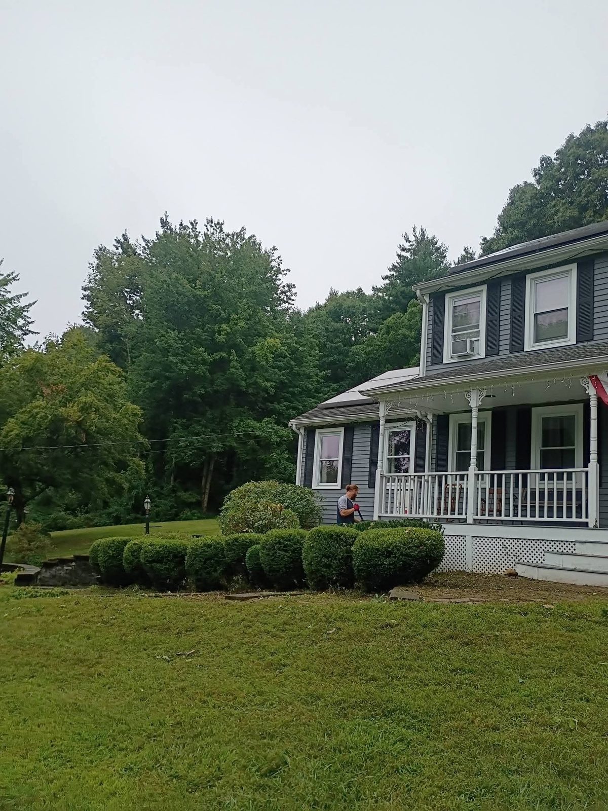 Trimming round shrubs along a farmhouse porch