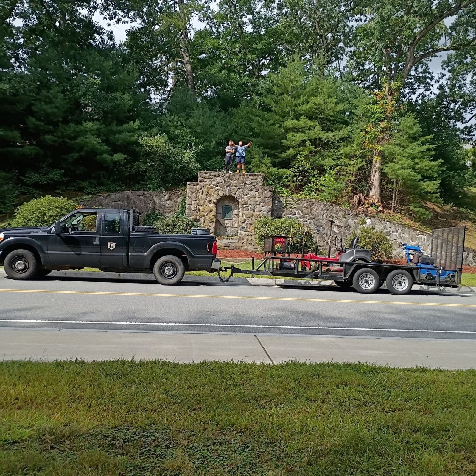 Black pickup and loaded equipment trailer parked at a job